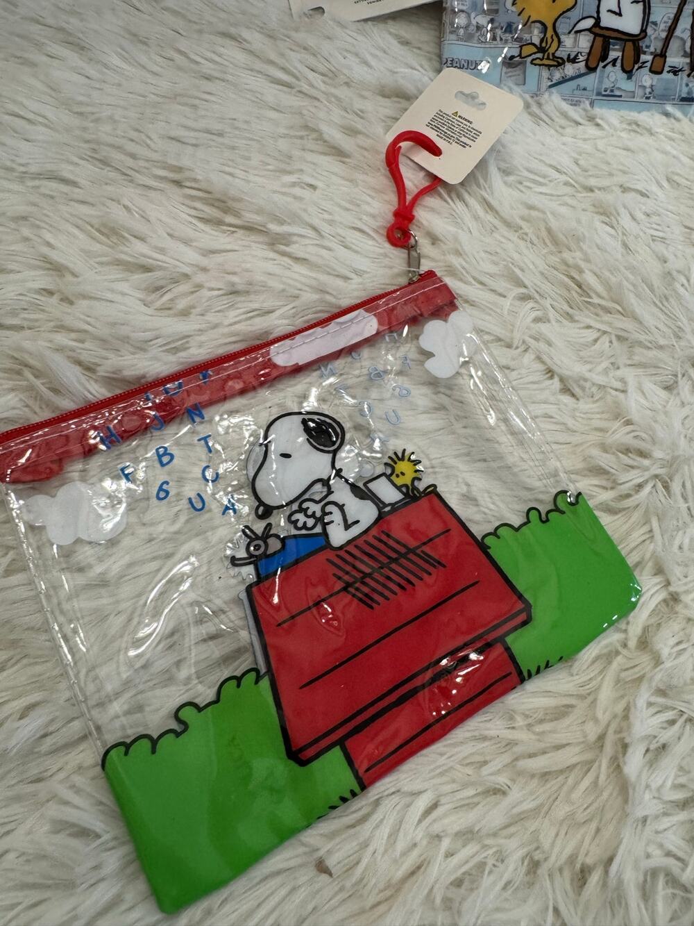 Peanuts Snoopy clear pouch with Snoopy sitting on a red doghouse typing